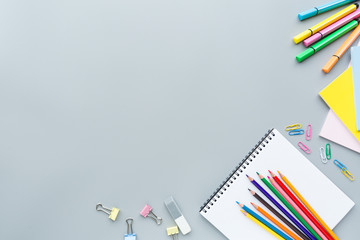 Fototapeta premium School supplies stationery, colour pencils, clips, paper on gray background, back to school concept with copy space for text, overhead, modern elementary education. flat lay, top view, mockup