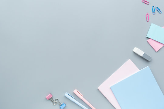 School supplies stationery, colour pencils, clips, paper on gray background, back to school concept with copy space for text, overhead, modern elementary education. flat lay, top view, mockup