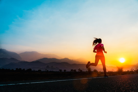 Young woman enjoys running outside with beautiful summer evening in the countryside.