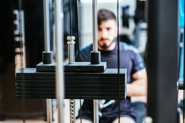 weights of a gym machine with boy in the background
