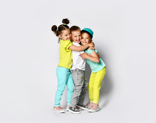 Studio portrait of children on a light background: full body shot of three children in bright...