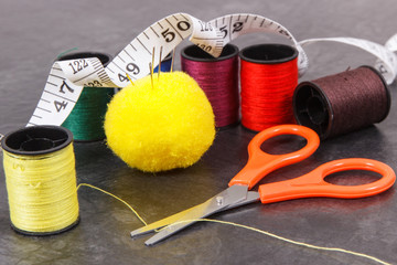 Accessories and tools for using in sewing. Spools of thread, needle, scissors and centimeter