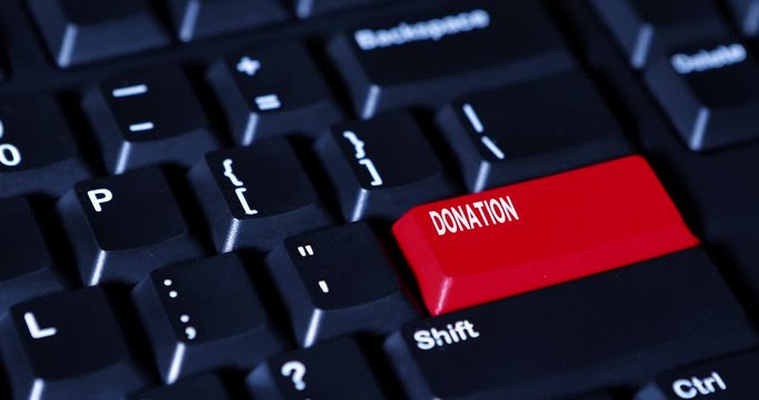 Hand pressing a Donation button on the keyboard computer. Shot in 4k resolution