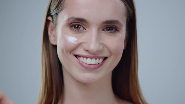 Portrait young woman uses creams for the beauty of her face daytime and night-time concept for fresh moisturized skin beautiful closeup cosmetic face happy health healthy isolated model slow motion