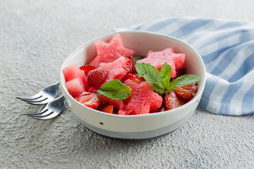 Summer salad with watermelon and strawberry on concrete background table