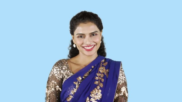 Young Indian woman wearing saree clothes and winking her eyes. Shot in 4k resolution