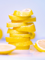 Pile of juicy lemon slices on light background, close up view. Set of cutted slices on light desk....