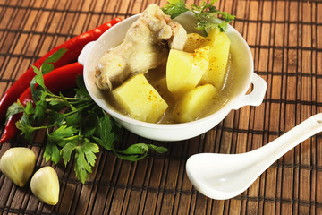 ready chicken and potatoes in a porcelain bowl. spicy seasonings to meat.