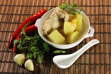 ready chicken and potatoes in a porcelain bowl. spicy seasonings to meat.