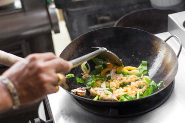 Man hand is cooking Asian style in a pan