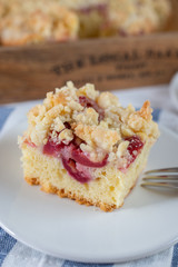 crumble cake in a baking form and pieces of the cake on a table