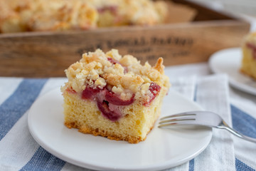 crumble cake in a baking form and pieces of the cake on a table