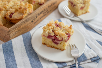 crumble cake in a baking form and pieces of the cake on a table
