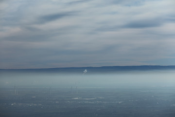 Windräder unter einer Nebeldecke und Wolkendecke