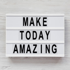 'Make today amazing' words on a modern board on a white wooden surface. From above, overhead, flat lay, top view. Closeup.