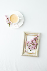 Obraz na płótnie Canvas Cup of coffee, lilac branch and frame on white background. Flat lay, top view, copy space, wedding, female morning breakfast, woman day concept