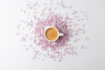 Morning breakfast with coffee cup and lilac flowers on white background. Flat lay, top view women background. Minimal concept, wedding, valentine day