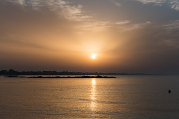 Fototapeta na wymiar A Small Island Visible at Sunset near the Darsena Beach in Rimini, Italy