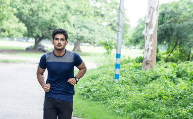 Athletic young man running in the sports ground. Healthy lifestyle , fitness and sports concept.