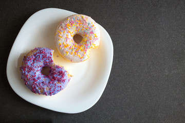 Two donuts with icing on a plate