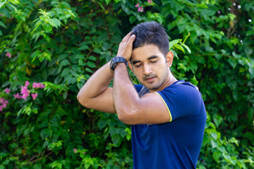 Naklejka na ściany i meble Portrait of young Indian man wearing sports wear and wrist watch in park