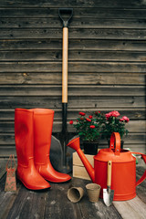 Shovel, watering can, hat, rubber boots, box of flowers, gloves and garden tools