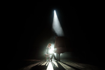 Close up view of a girl plays piano in the concert hall at scene