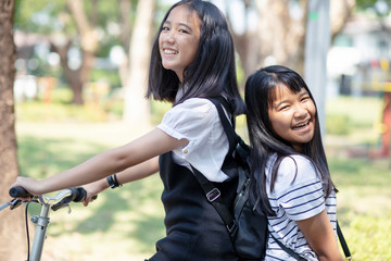 cheerful asian teenager happiness emotion riding bicycle in public park