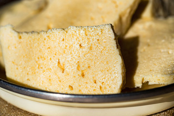 Homemade cheese Bryndza cut in slices in bowl close