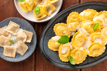 Italian Food. A closeup of an assortment of various ravioli, shot from the top on a dark rustic wooden background