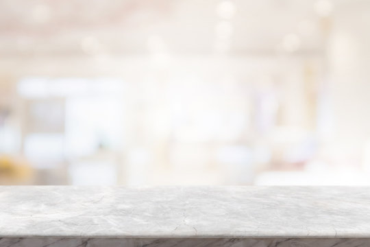 Empty white marble stone table top on blur bokeh cafe and restaurent interior background - can be used for display or montage your products