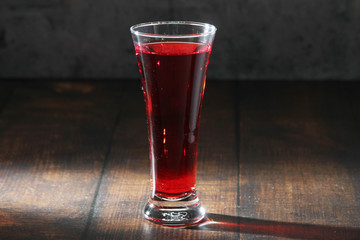 Red juicy drink in a high beer glass	