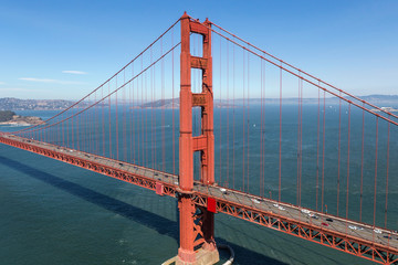 Aerial view of the Golden Gate Bridge tower with San Francisco Bay in background.