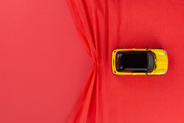 A car figurine on a red background