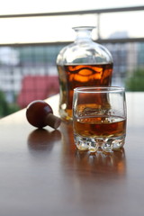 glass of whiskey and ice on wooden table