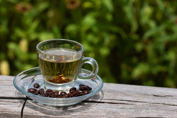 Hot coffee and Tea in a glass On the timber In the flower garden