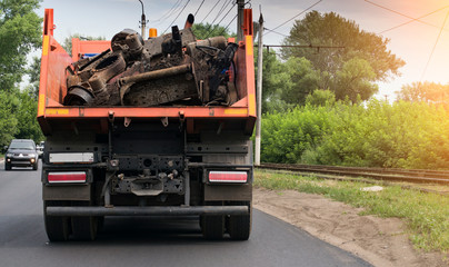 rear view of a dump truck loaded on the road laden with scrap metal - obrazy, fototapety, plakaty