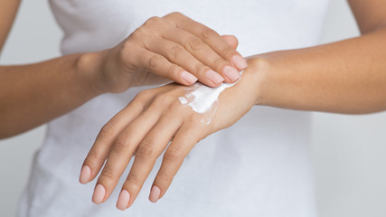 Skin Nutrition. Woman Spreading Nourishing Cream On Hand