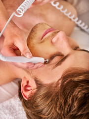Galvanic stimulation facial treatment on man face in beauty salon. Men Hydradermie Ionization in day spa .