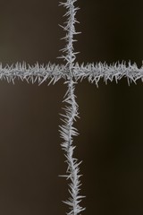 Vereistes Kreuz eines Maschendraht Zaun