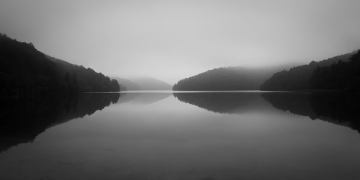 See mit Wald H&uuml;gel im Herbst Nebel