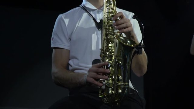 Close up of a saxophone player performing on stage of a concert