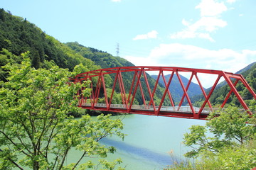 秘境のような美しい川と緑と赤い橋