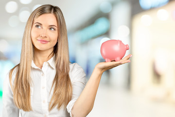Naklejka premium Young woman with a piggy bank
