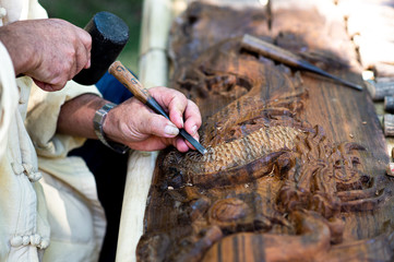 Closeup hands of local craftman carve with gouge tool and create an amazing Thai Northern handcraft...