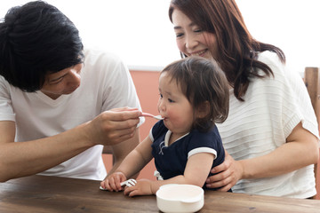 子供にご飯を食べさせる両親