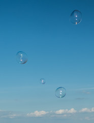 Large, soap bubbles against the blue sky. Lake Ladoga, sunny day.