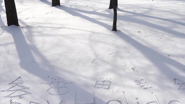 Inscription of happy holidays on snow. Shooting in the winter.