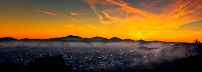 Red-yellow sunrise with fog in a valley