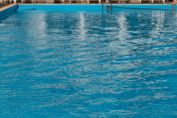 Blurred water texture in summer pool close up.
